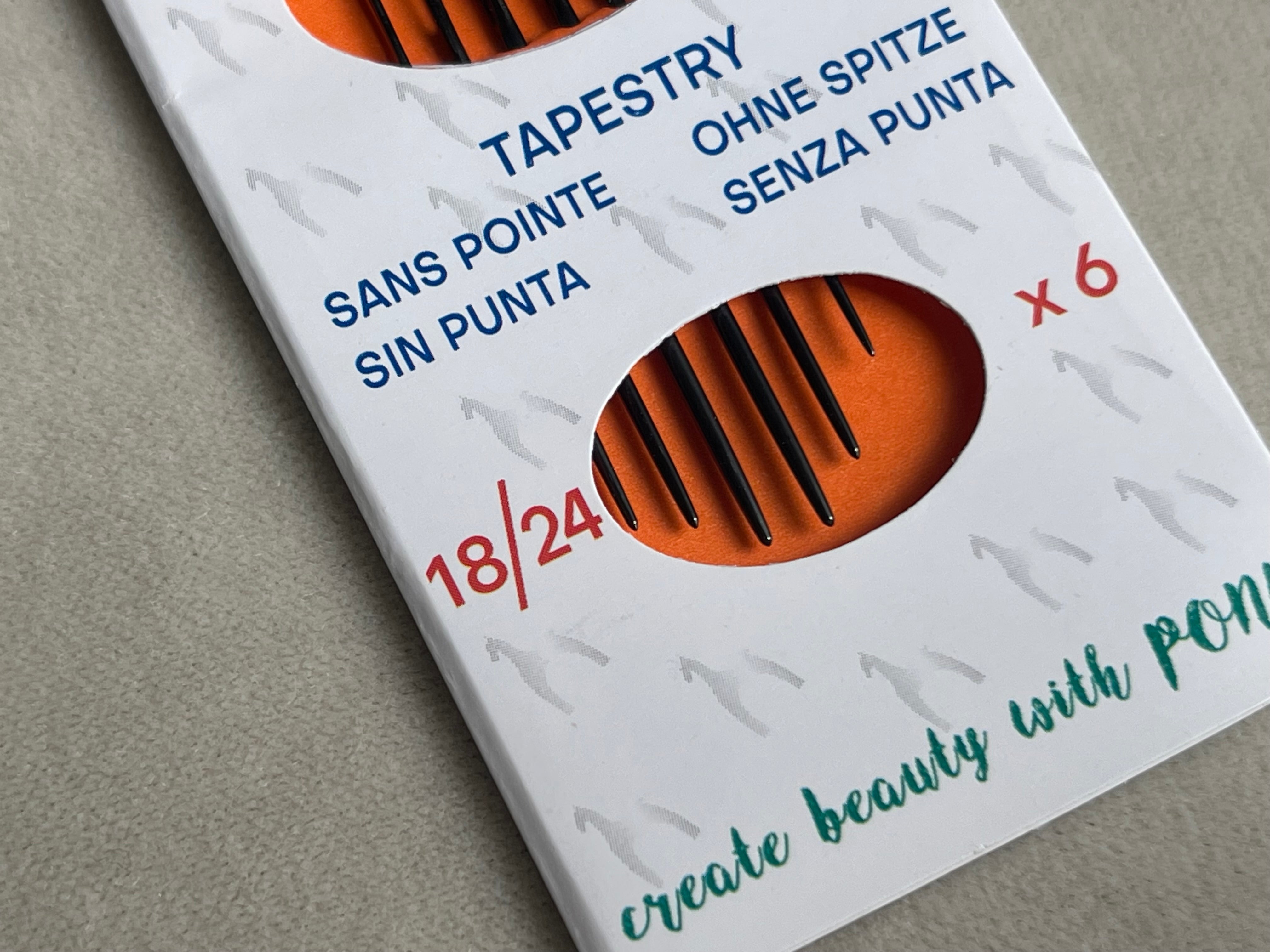 Packaging of embroidery needles with brand name on a neutral background