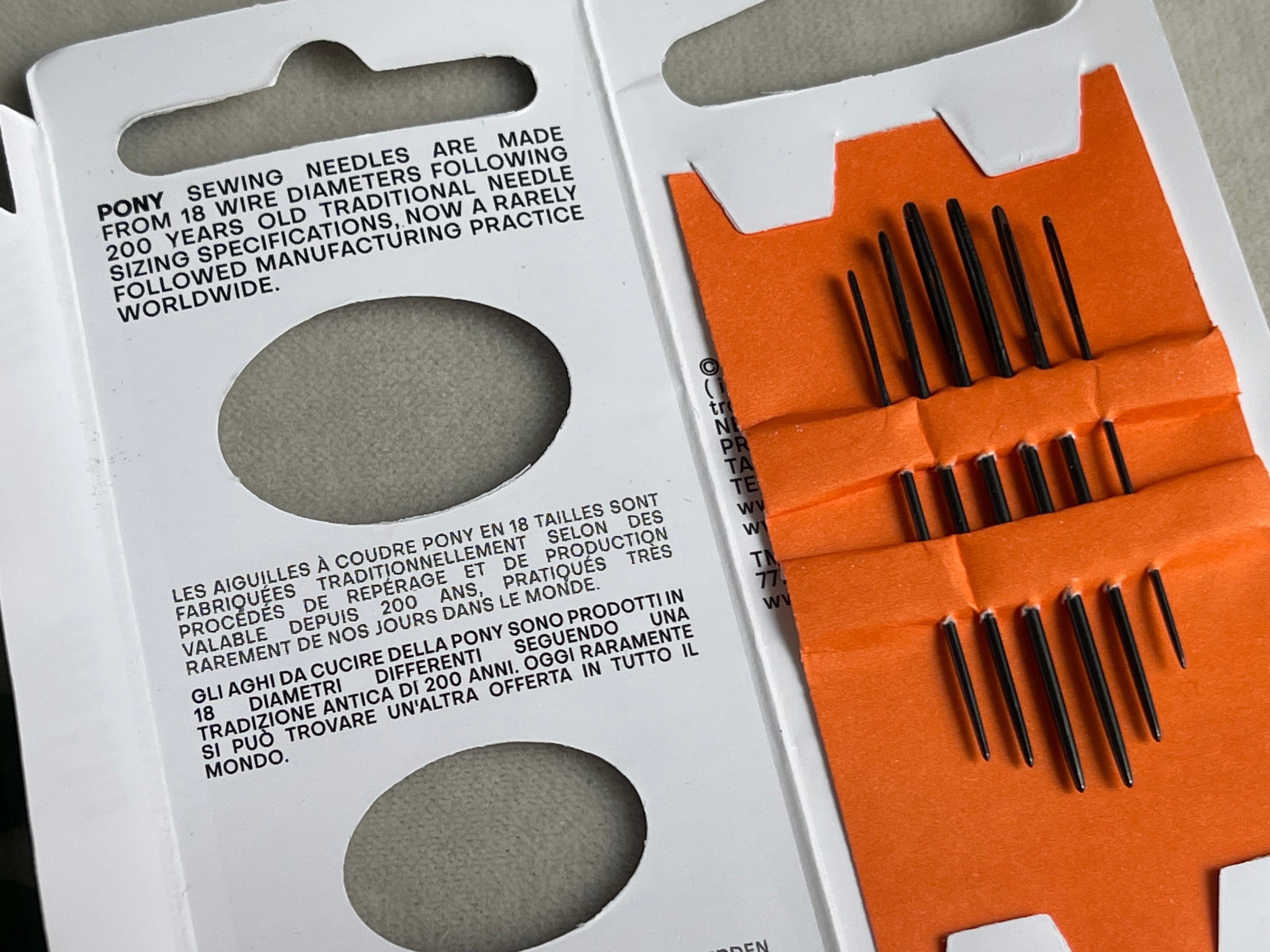 Pony sewing needles in an open package with needle information on a white background