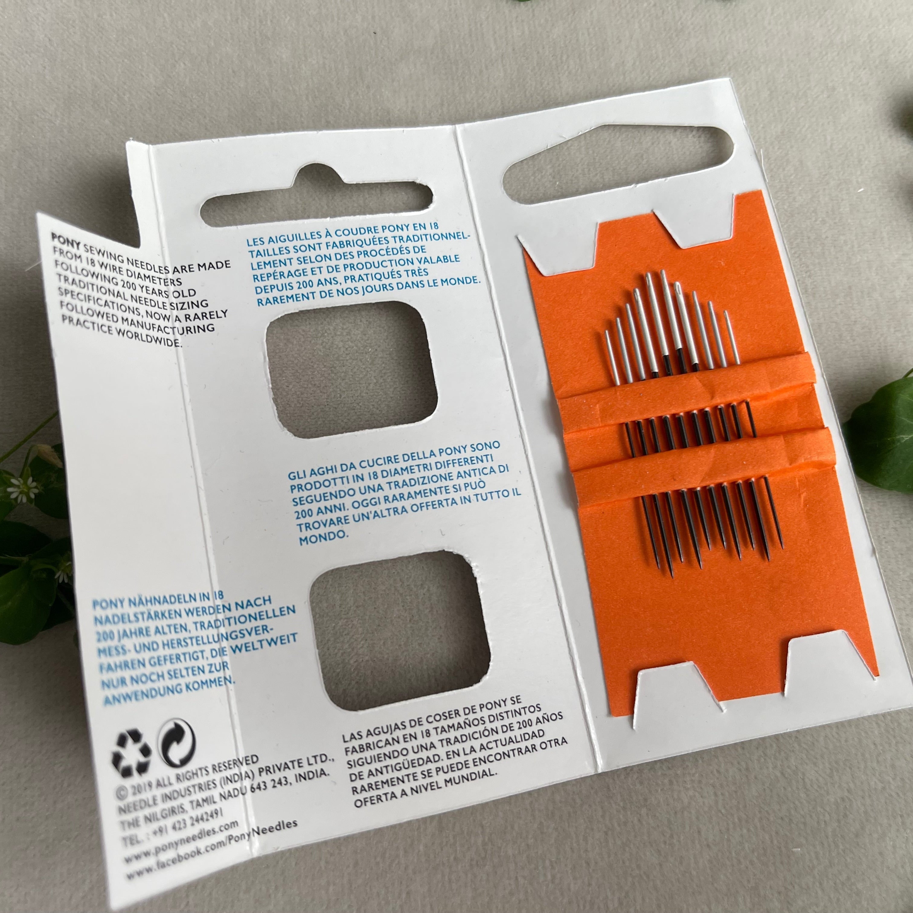 Packaging of needle set with orange needles on a gray background