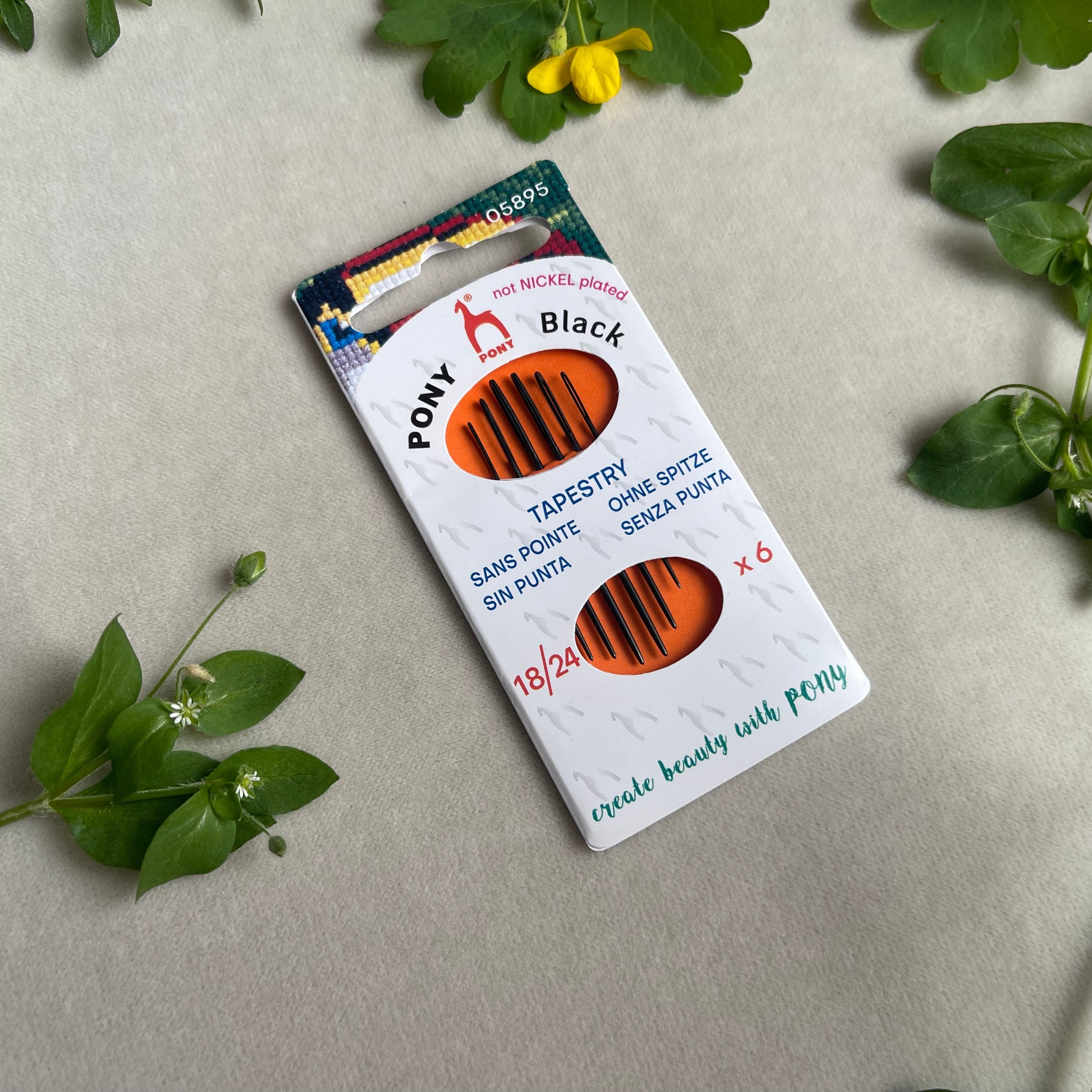 Pony Black tapestry needles packaging on a light gray background with green leaves.
