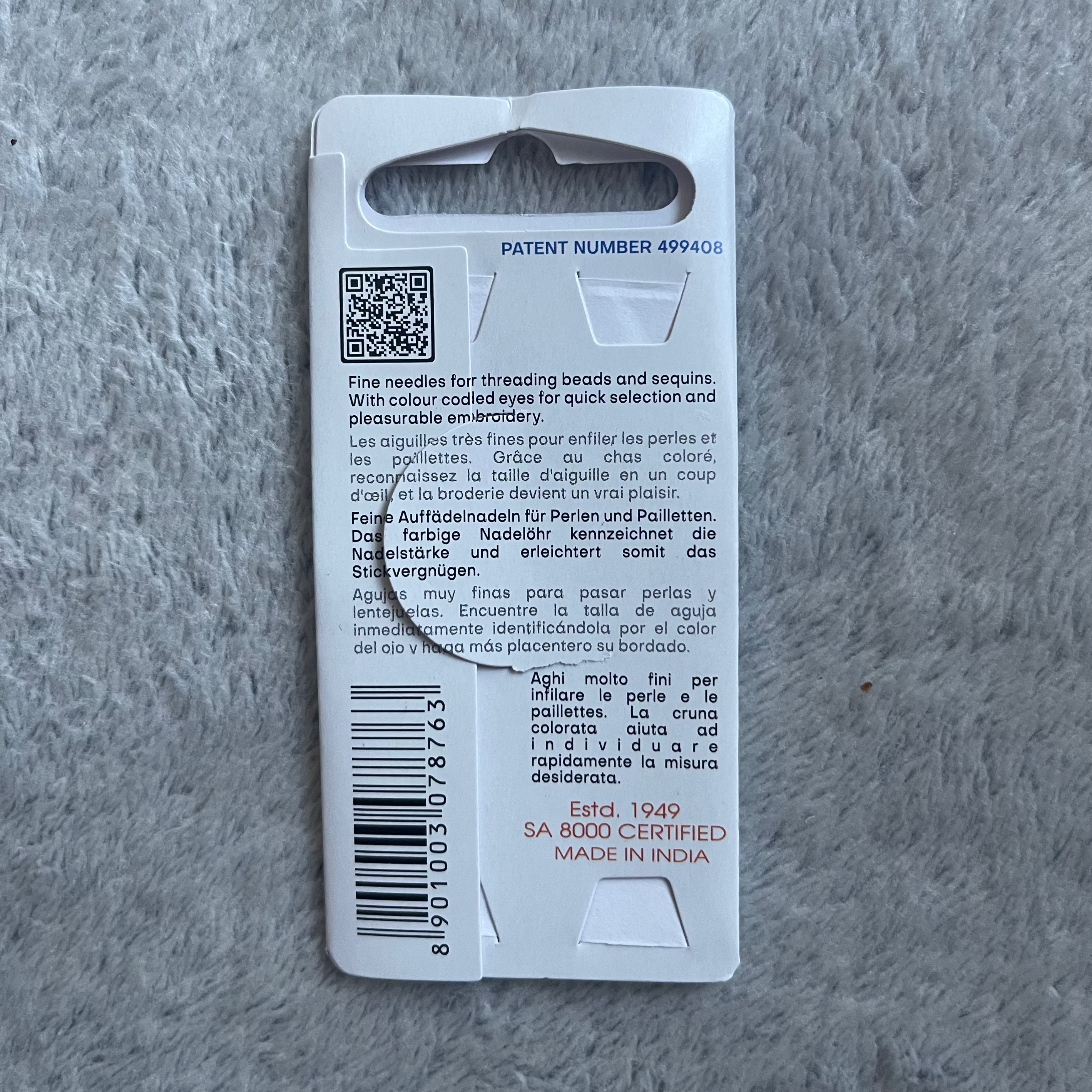 Back of a product packaging with text and QR code on a gray textured surface