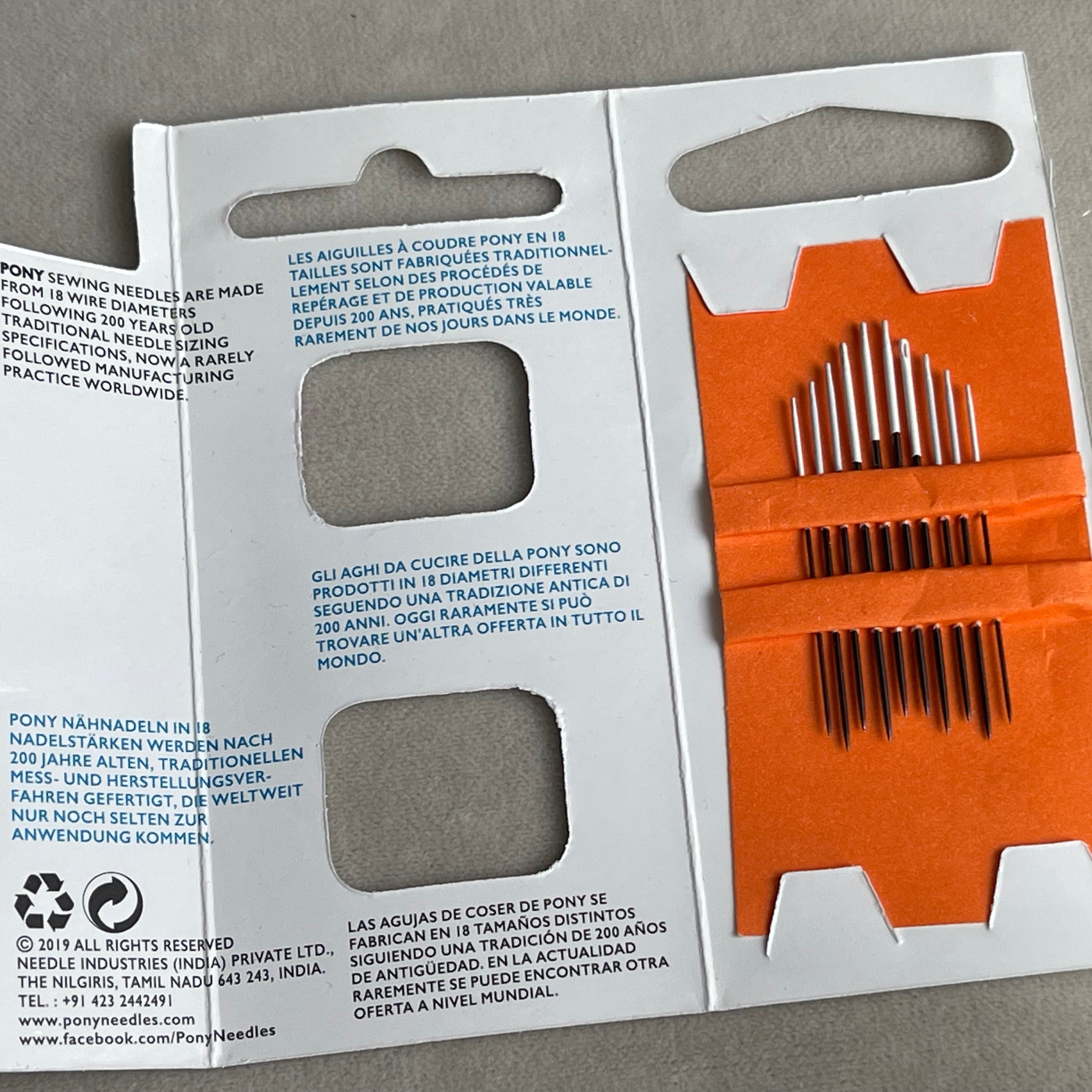 Pony needle case with needles on a gray background